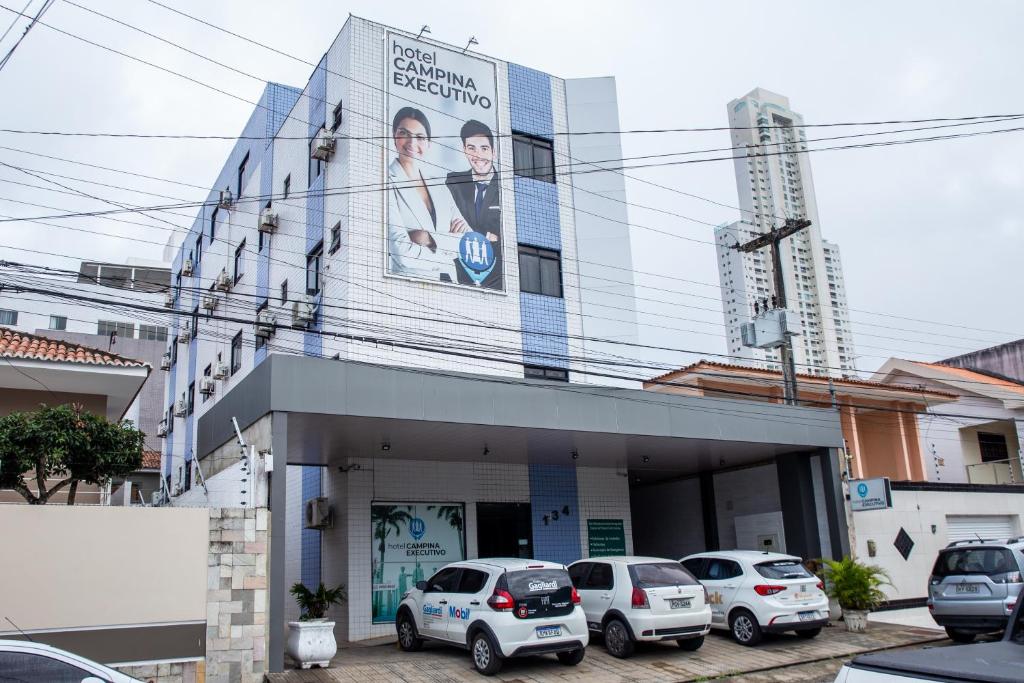 a building with cars parked in front of it at Hotel Campina Executivo in Campina Grande
