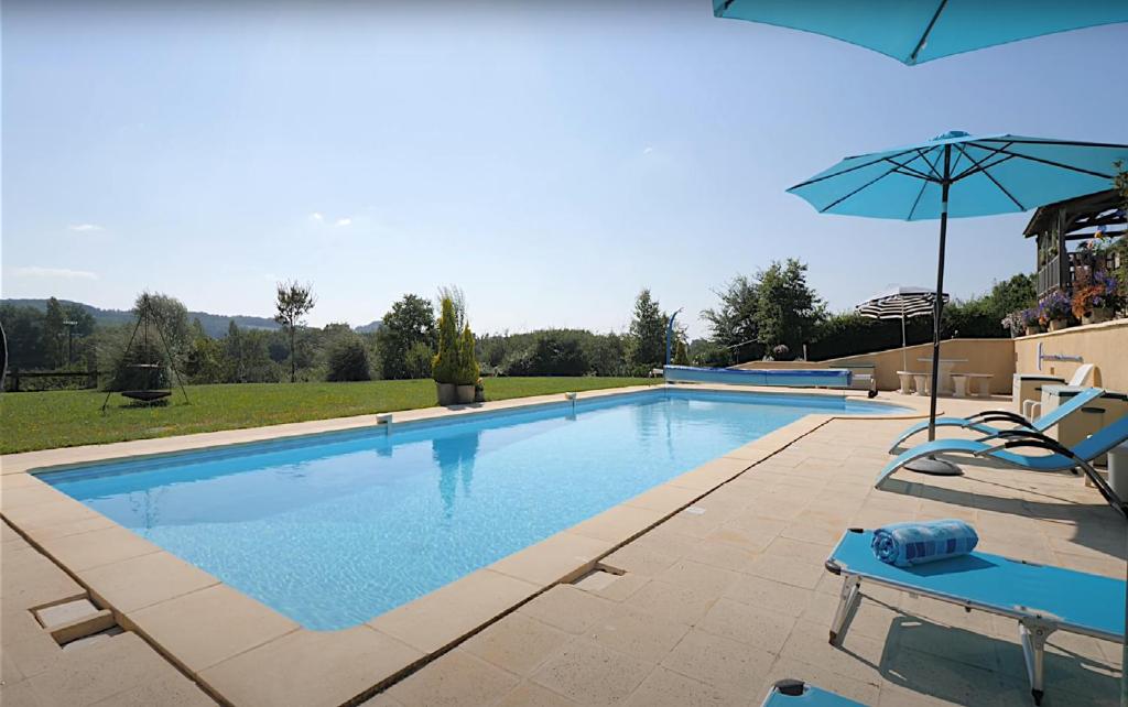 a swimming pool with two chairs and an umbrella at Les Bouges in Salles