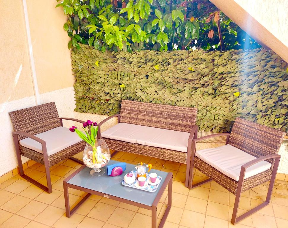 two wicker chairs and a table with a tray of food at CapoSud - Appartamento Giglio in Punta Secca