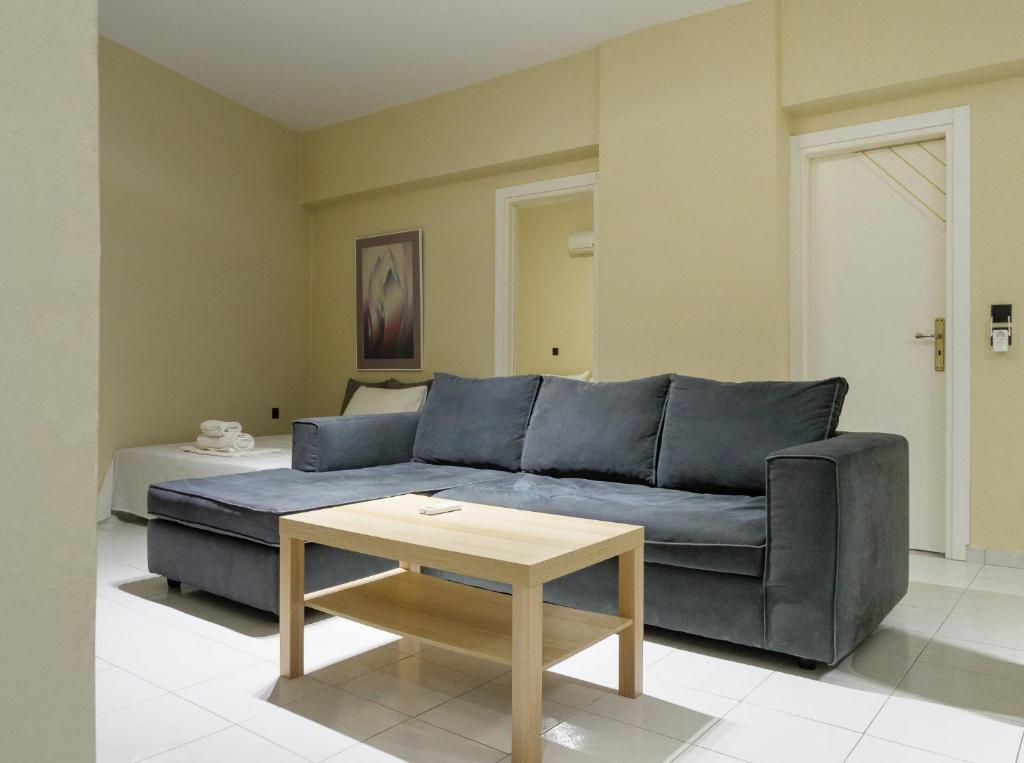 Apartment Lazarous 1 في Apolakkiá: غرفة معيشة مع أريكة زرقاء وطاولة