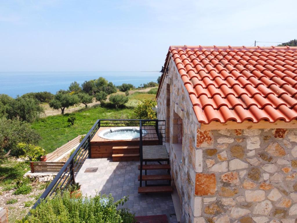 una casa de piedra con una escalera junto a un edificio en Casa Petra - Stone Cottage Farmhouses en Argasi