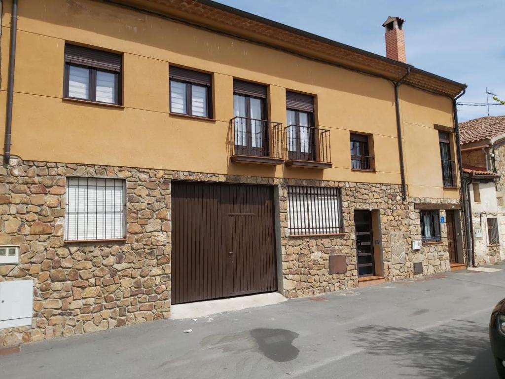 un edificio con una puerta de garaje marrón y ventanas en CORRAL DEL DUQUE II en San Cristóbal de Segovia