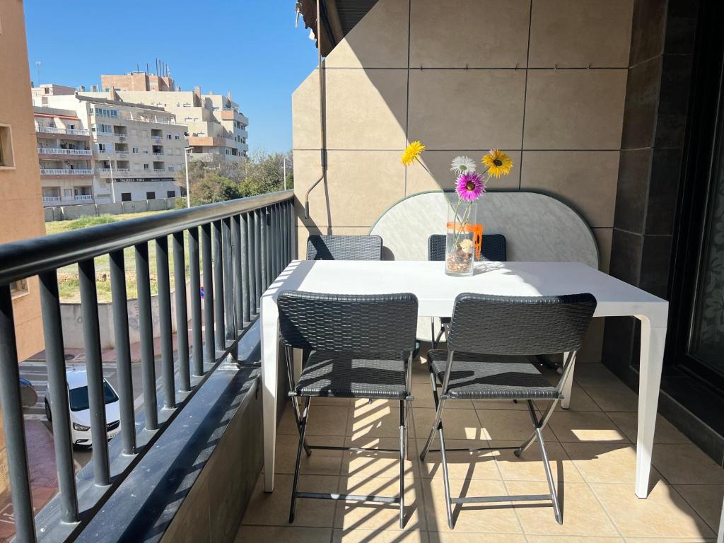 Biały stół i krzesła na balkonie w obiekcie APARTAMENTO LA MATA w mieście La Mata