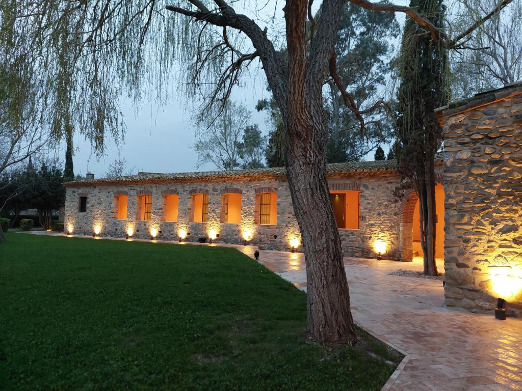 a stone building with lights in front of it at HOTEL MAS ARET in Peralada