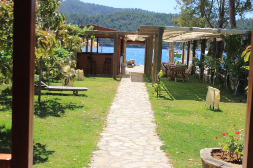 a walkway in a yard next to the water at Sakin Vadi Winehouse in Orhaniye