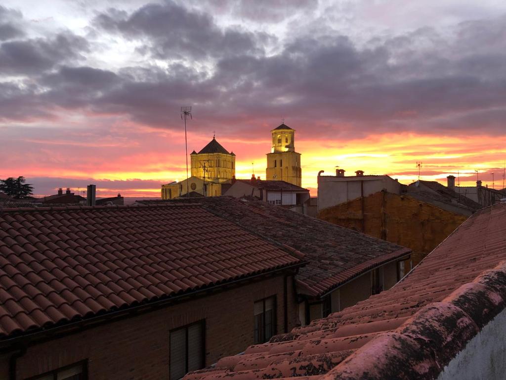 - une vue sur les toits des bâtiments au coucher du soleil dans l'établissement Ático en la plaza de Toro con garaje, à Toro