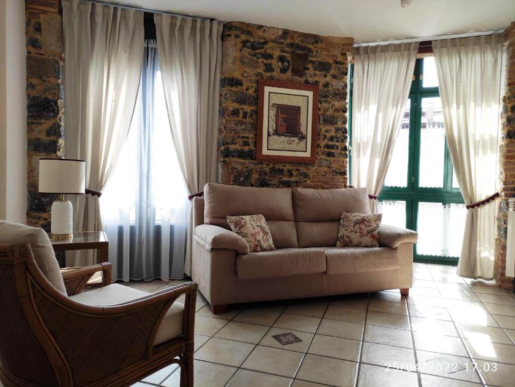 a living room with a couch and some windows at Apartamento Campomanes in Villaviciosa