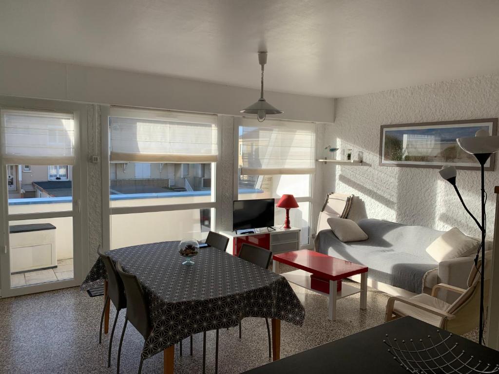 uma sala de estar com um sofá e uma mesa em Petite escapade à la Picardière em Fort-Mahon-Plage