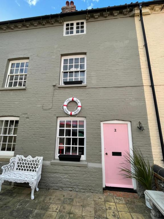 a pink door on the side of a house at The Old Crab Shop. PERFECT location & sea views. in Cromer