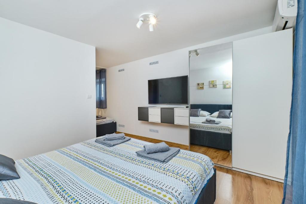1 Schlafzimmer mit 2 Betten und einem großen Spiegel in der Unterkunft Apartments Hemetek in Veli Lošinj
