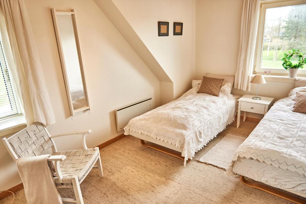 a bedroom with a bed and a chair in it at Stylish vacation home - close to sea and nature in Hejls