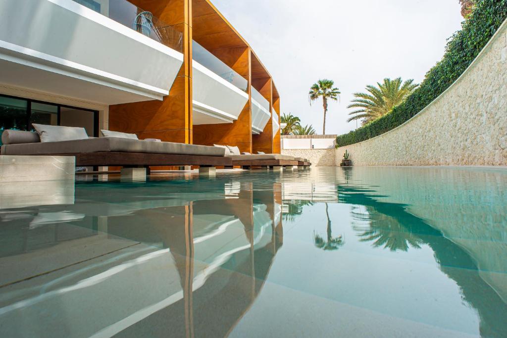 une maison avec une piscine à côté d'un bâtiment dans l'établissement TenSuites - Adults Only, à Maspalomas