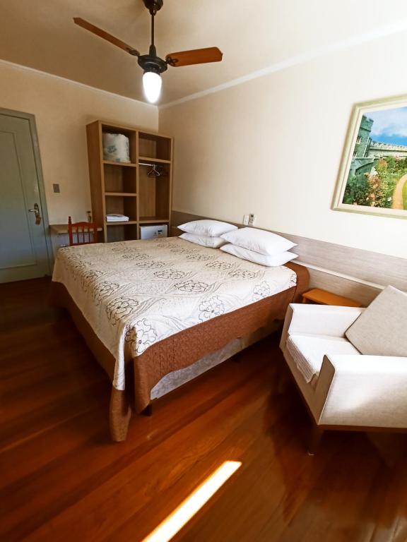 Pousada Tedesco في بينتو جونكالفيس: غرفة نوم بسرير ومروحة سقف