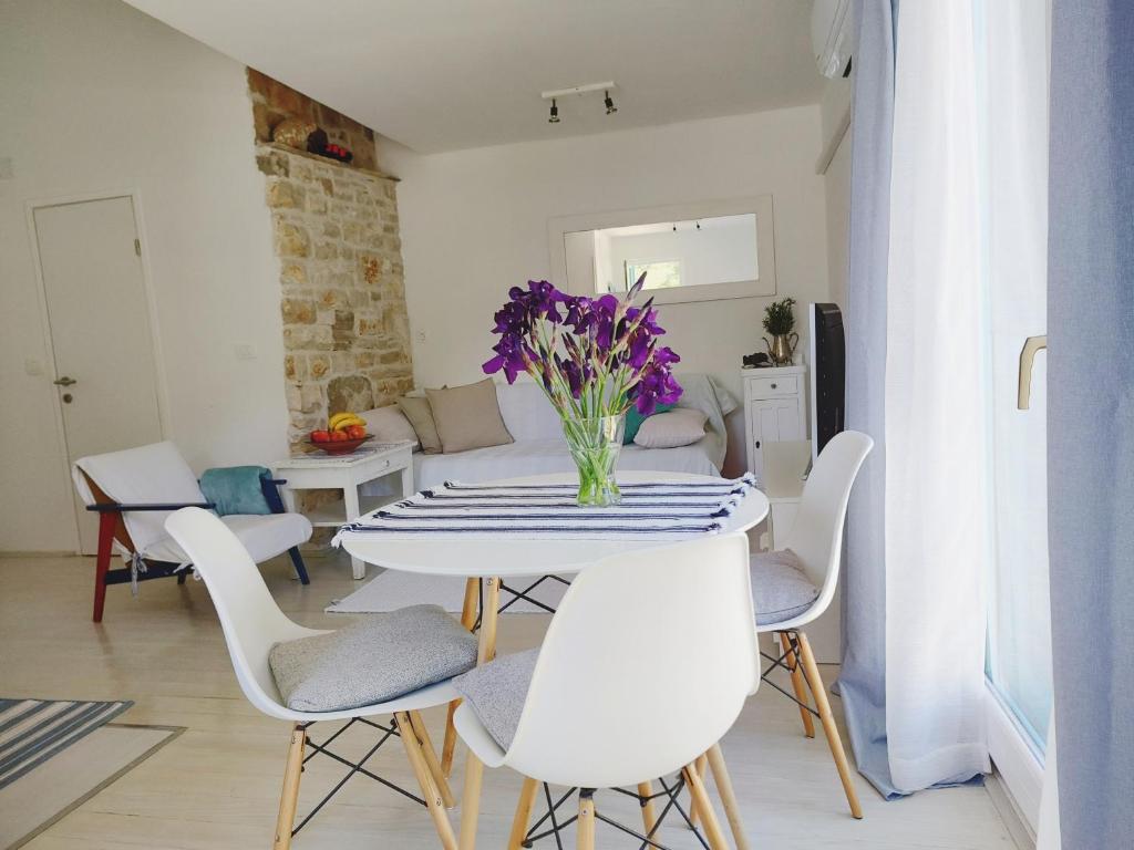 una sala da pranzo bianca con tavolo e sedie di Apartment Garden, Korcula a Blato