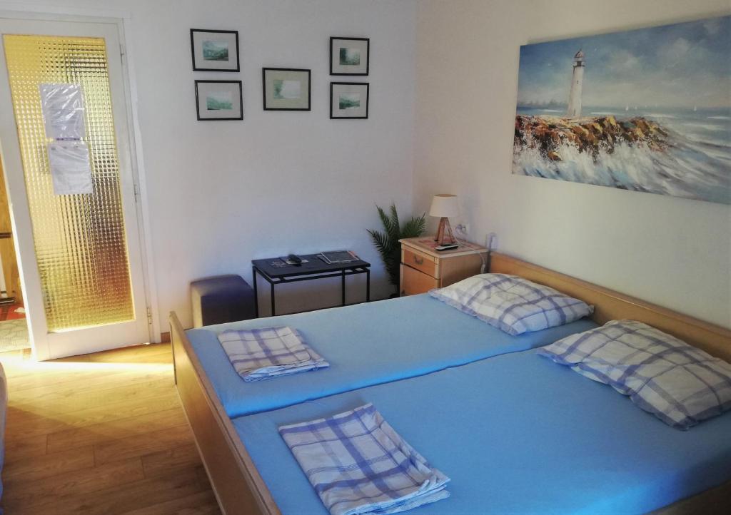 ein Schlafzimmer mit einem blauen Bett in einem Zimmer in der Unterkunft Angela Apartments -Lopar in Lopar