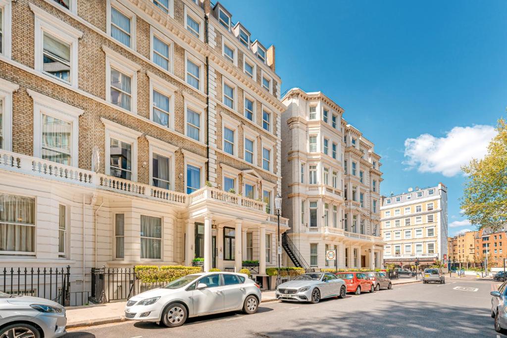 una fila de coches estacionados frente a los edificios en Ashburn Court Apartments, en Londres