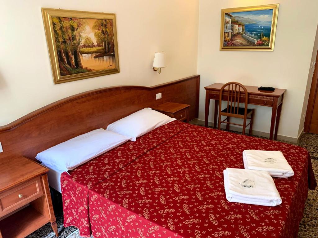 a hotel room with a red bed with two towels on it at Paramount in Rome