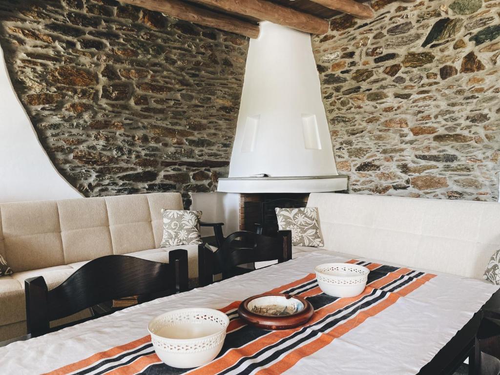 a dining room with a table and a stone wall at Zefis Villas in Karistos