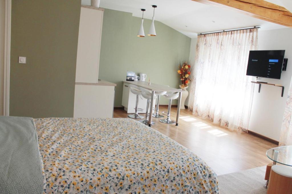 ein Schlafzimmer mit einem Bett und einem Tisch in einem Zimmer in der Unterkunft Saint Etienne : appartement Châteaucreux 40 M2 in Saint-Étienne