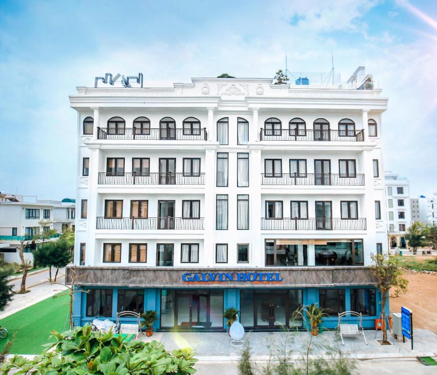 a white building with a sign on it at Galvin Hotel in Sầm Sơn