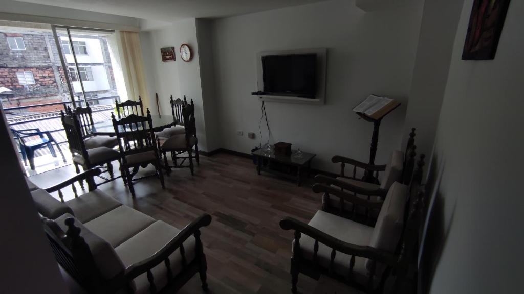 a room with chairs and a flat screen tv at APARTAMENTO CÓMODO, ILUMINADO Y CENTRAL EN MANIZALES in Manizales