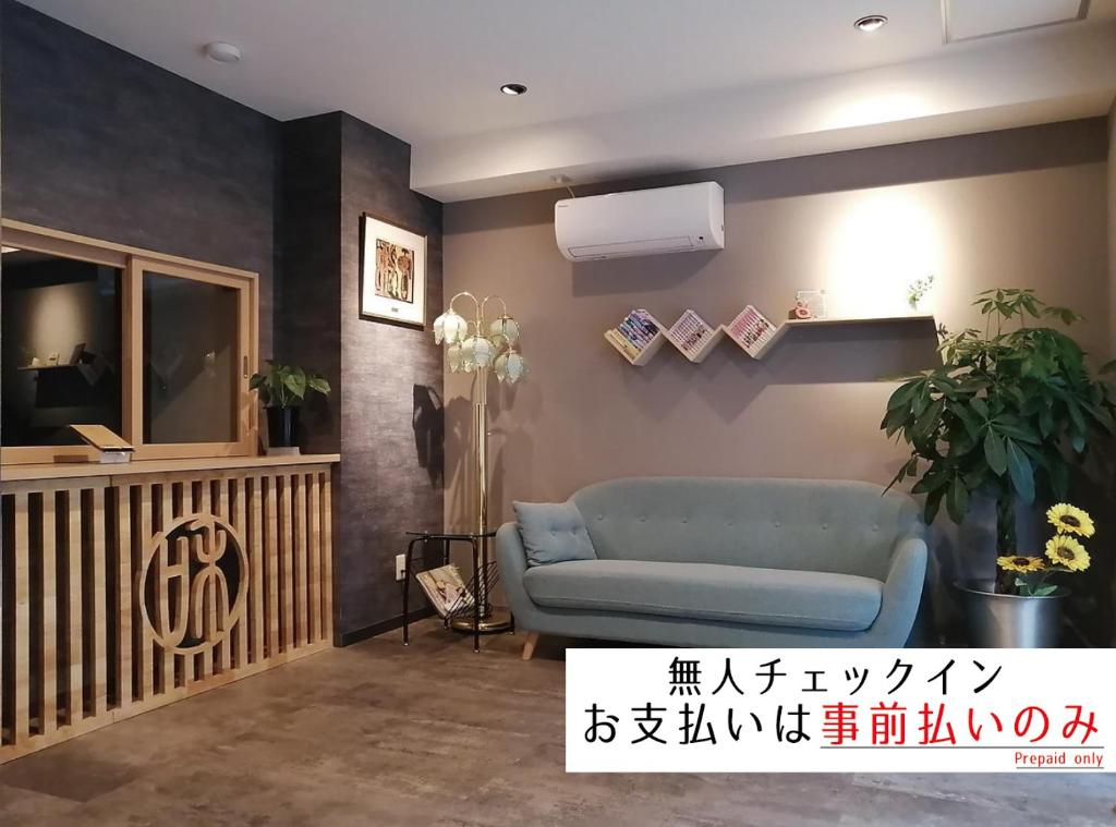 una sala de estar con un sofá azul en una habitación en 東京日和, en Tokio