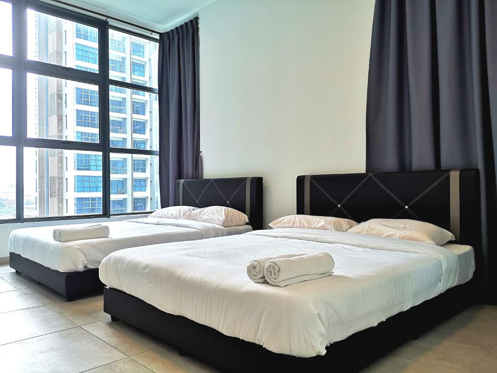 two beds in a room with two large windows at Golden House-Atlantis Residence in Malacca