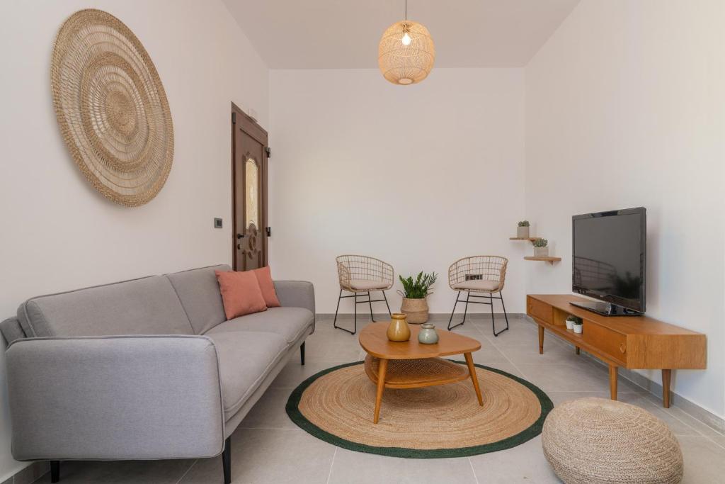 salon z kanapą i telewizorem w obiekcie Casa il Fiume w mieście Alikes