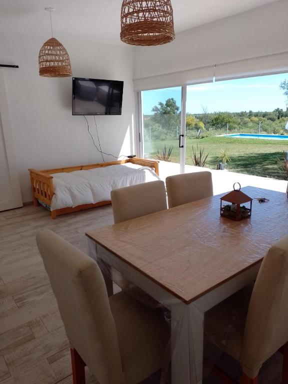 a living room with a dining room table and a bed at Los colibries in San Pedro