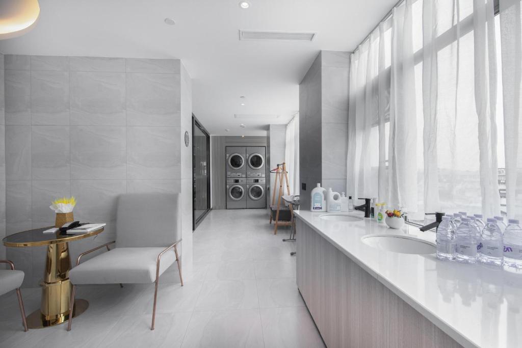 a bathroom with two sinks and two washing machines at Atour Light Hotel Chengdu Wenjiang in Wenjiang