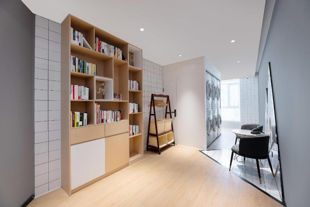 Cette chambre comprend une bibliothèque, une table et une chaise. dans l'établissement Atour Hotel Lanzhou Xiguan Zhangye Road Pedestrian Street, à Lanzhou