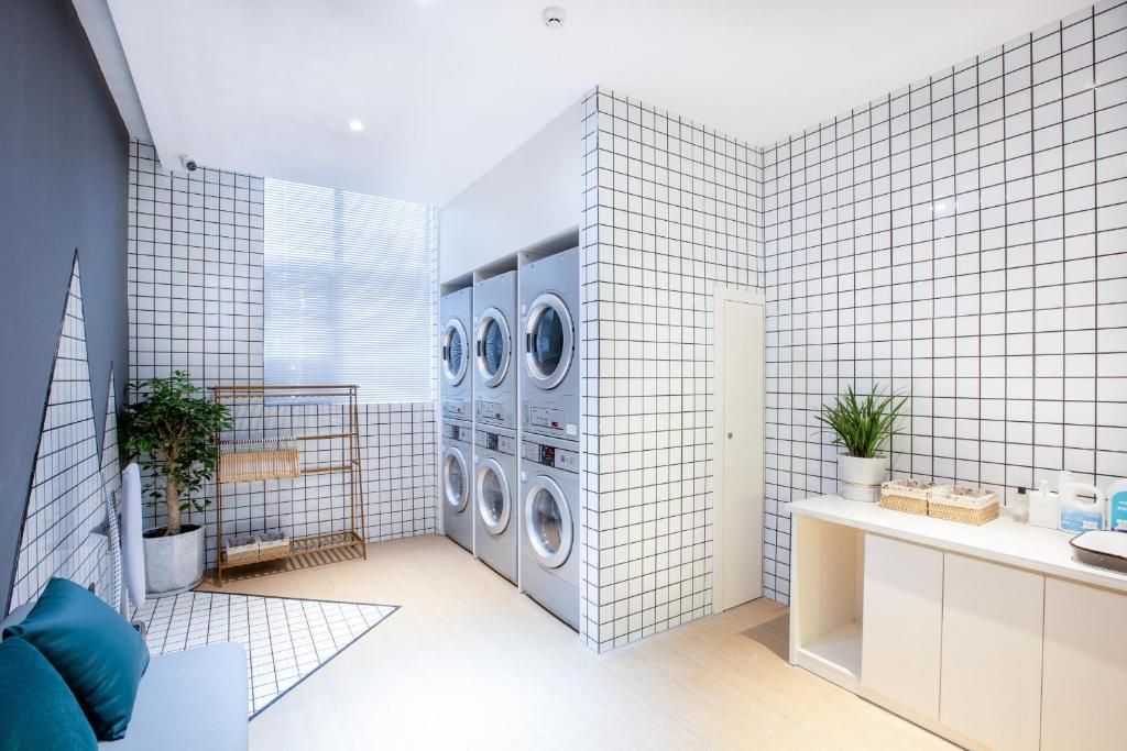 a laundry room with four washer and dryer machines at Atour Hotel Lhasa City Government in Lhasa