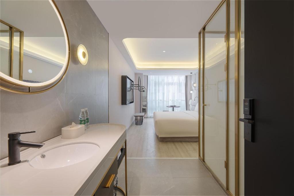 a bathroom with a sink and a mirror at Atour Light Hotel Qingdao International Convention Center in Qingdao