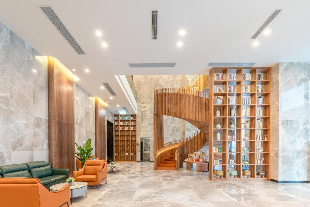 una biblioteca con una escalera de caracol y sillas naranjas en Atour X Hotel Xian Administration Center of North Railway Station, en Xi'an