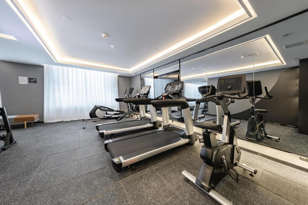 a gym with treadmills and ellipticals in a room at Atour Hotel Altay in Altay