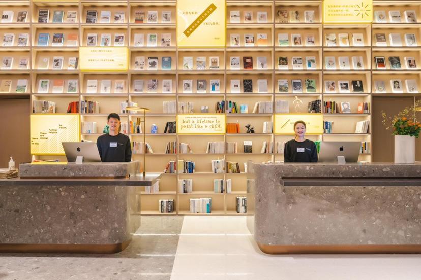 two people sitting at desks in a store with their laptops at Atour S Hotel Wuxi Nanchang Street in Wuxi