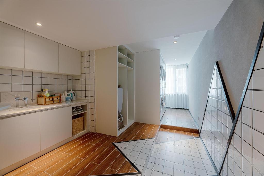 西安的住宿－西安浐灞国际会展中心亚朵酒店，厨房铺有木地板,配有白色橱柜。