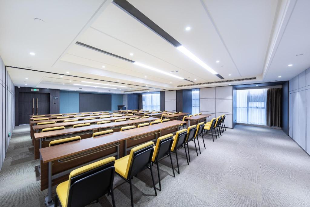 an empty lecture room with rows of tables and chairs at Atour Hotel Meishan Government Affairs Center in Meishan