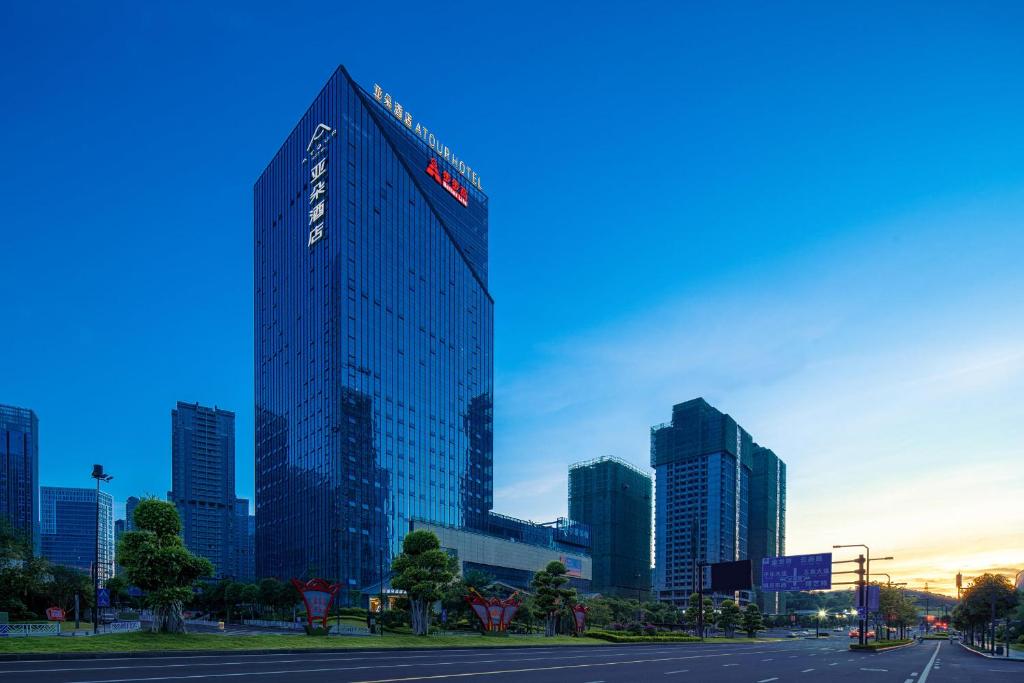 a tall building with a sign on it in a city at Atour Hotel Nanning Wuxiang Headquarter Base in Nanning