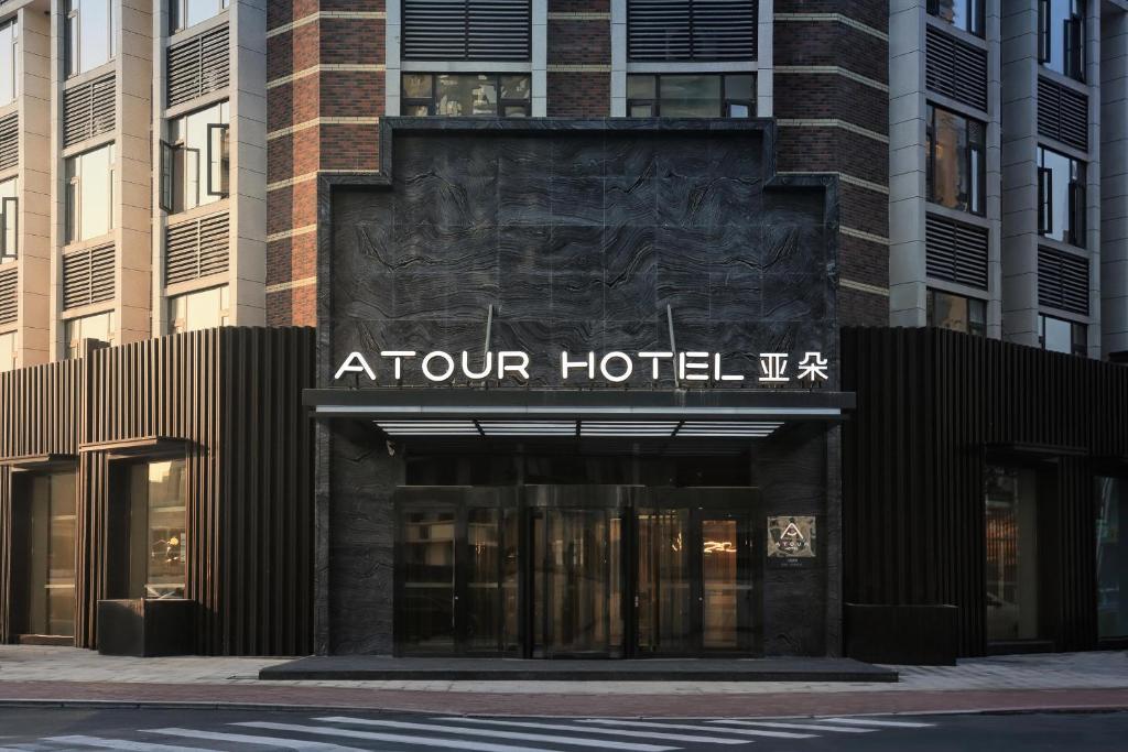 Atour Hotel Jinan High-Speed East Railway Station في جينان: مبنى فندق سياحي عليه لافته