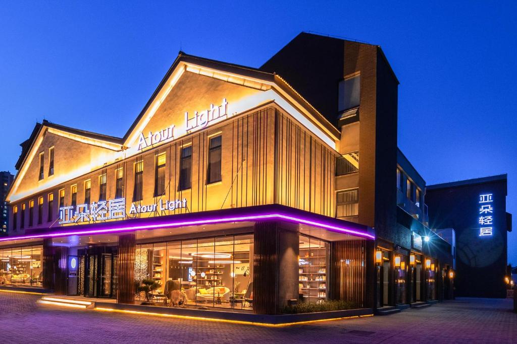 un edificio con luces púrpuras en el lateral. en Atour Light Hotel Jinan International Covention Centre, en Jinan