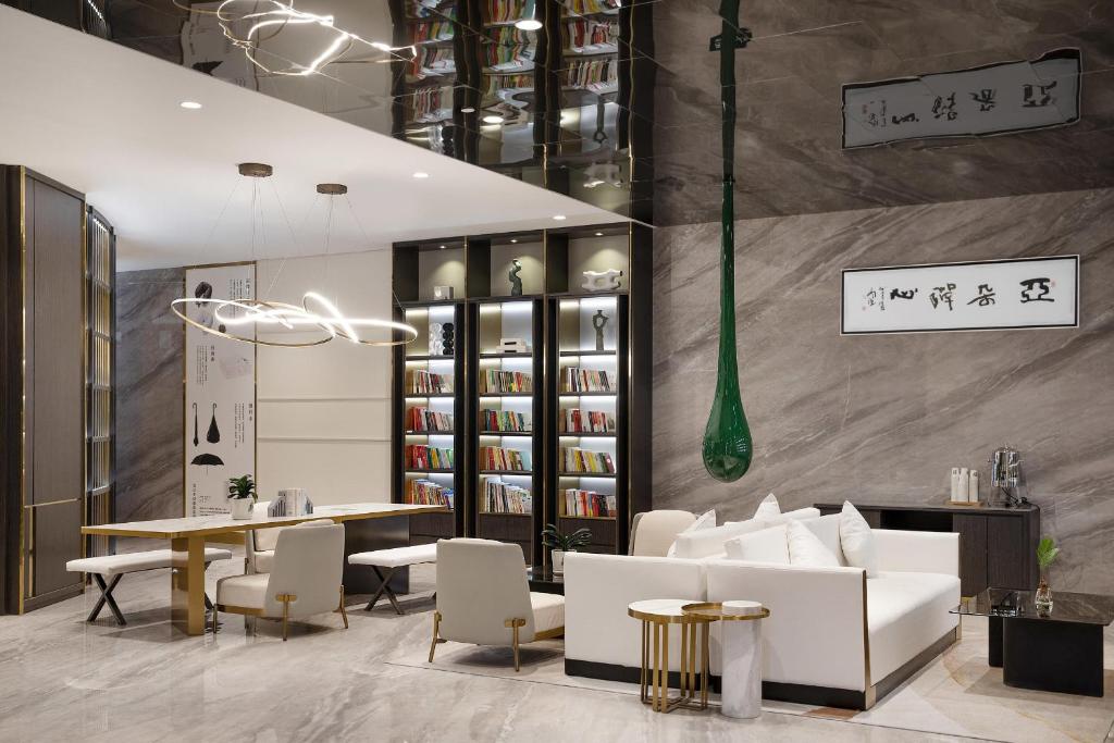 a restaurant with white furniture and a table and chairs at Atour Hotel Hotan Unity Plaza in Hoten