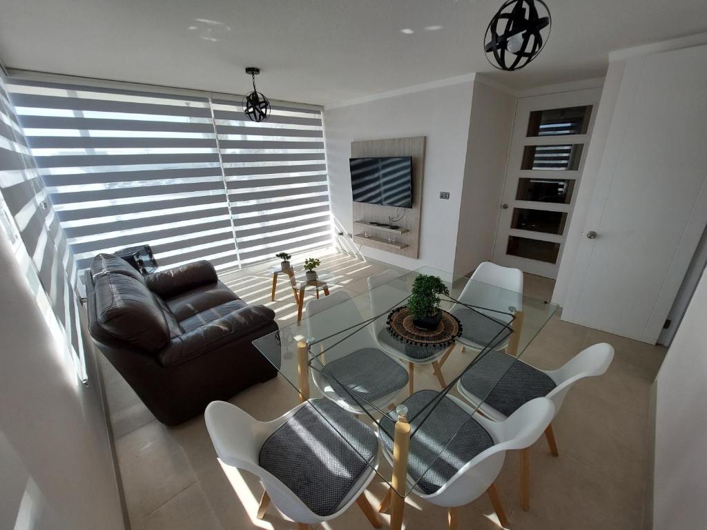 ein Wohnzimmer mit einem Glastisch und Stühlen in der Unterkunft Departamento Coquimbo - La Serena in Coquimbo