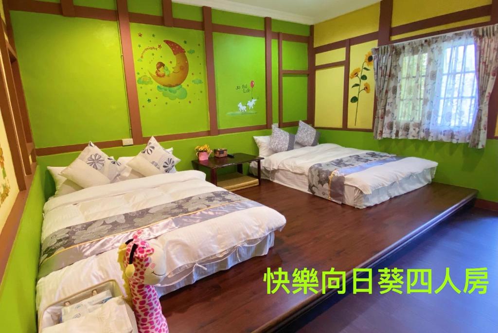 twee bedden in een kamer met groene muren bij Chambord Castle in Gukeng