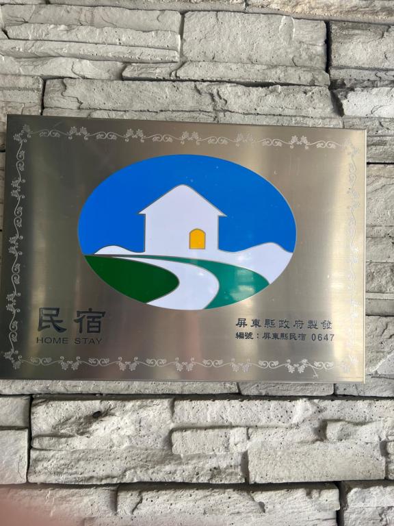 a sign hanging on a brick wall at CHI-YU B&B in Chaozhou