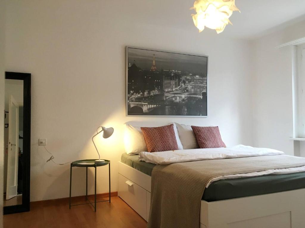 um quarto com uma cama com uma fotografia na parede em 2 Zimmer mit Balkon, zentrale ruhige Lage em St. Gallen