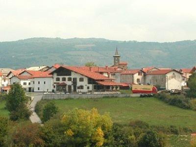 una ciudad con un edificio, una iglesia y un tren en MAITETXU HABITACION, en Viscarret-Guerendiáin