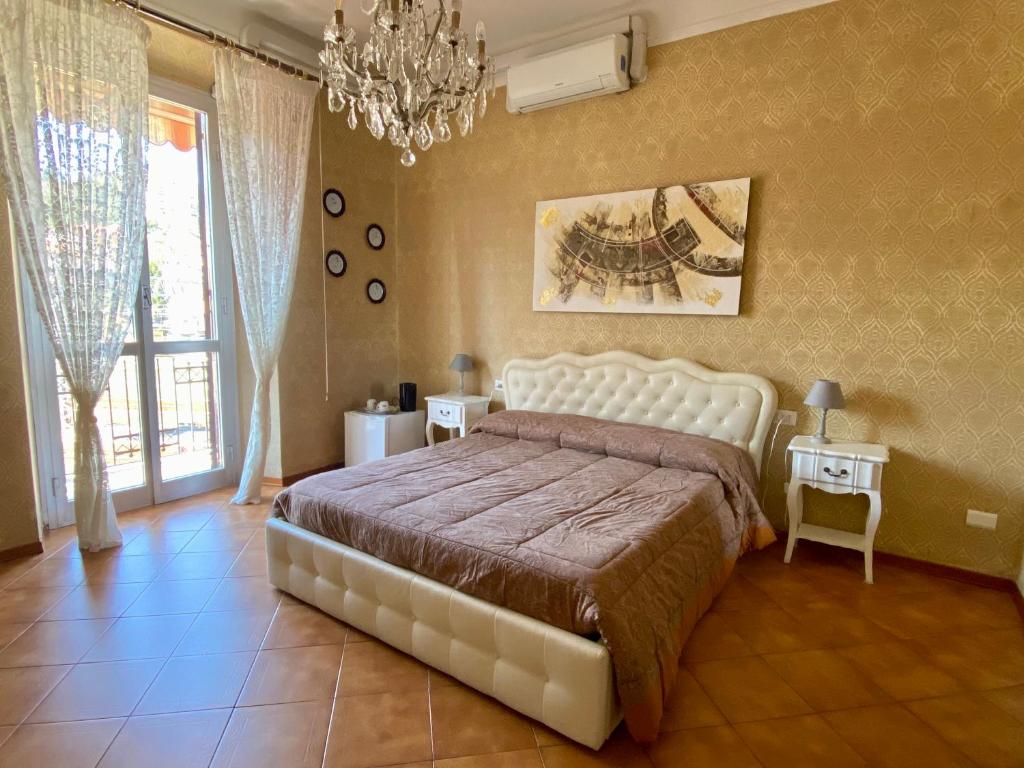 a bedroom with a large bed and a chandelier at 5 Terre Express in La Spezia