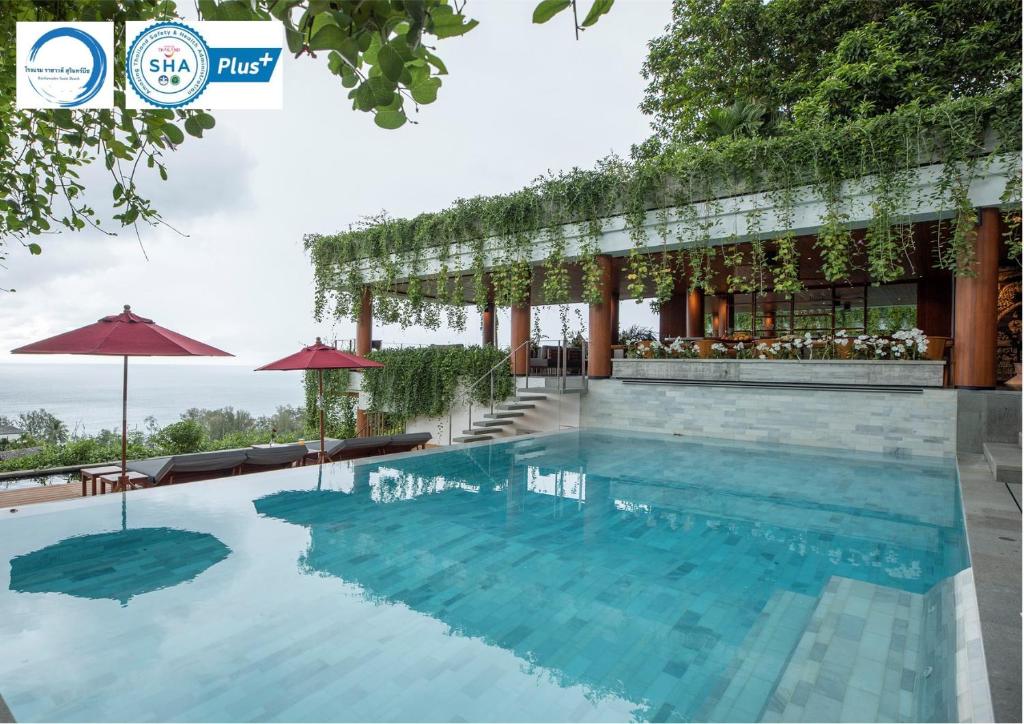 a swimming pool at a resort with a restaurant at Rachawadee Surin Beach-SHA Extra Plus in Surin Beach