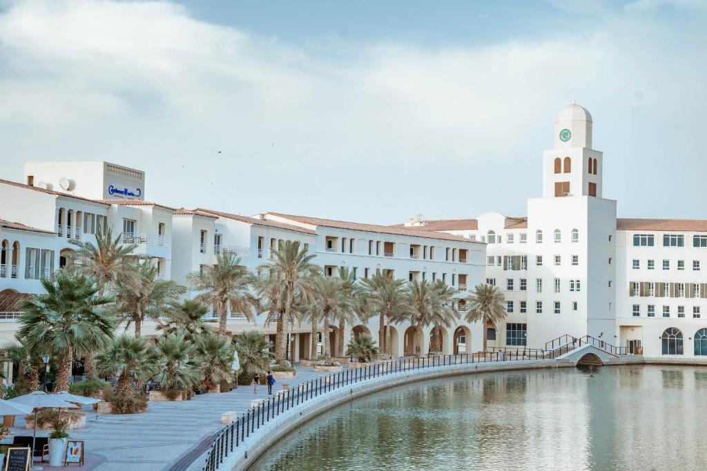 a building with a bridge over a body of water at Copthorne Lakeview Executive Apartments Dubai, Green Community in Dubai